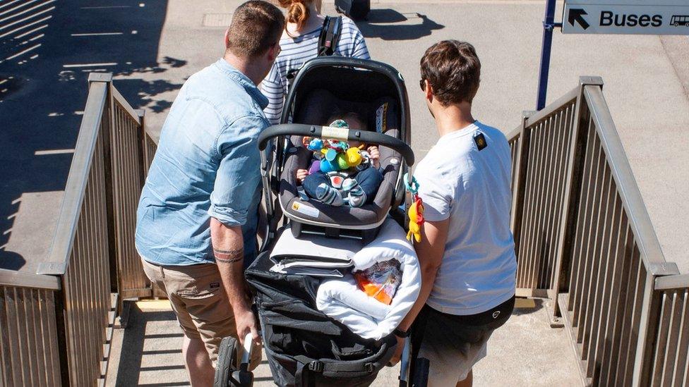 Men carry pram down stairs at Thirsk railway station
