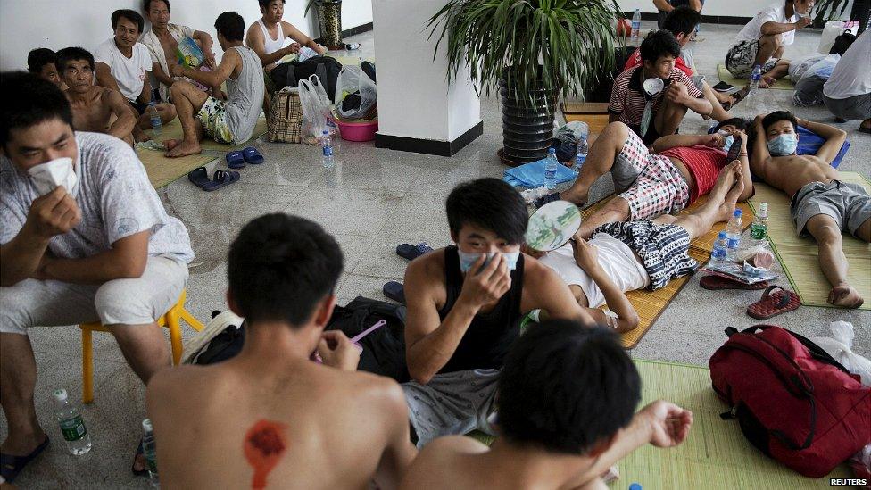 People affected by the Tianjin explosion at a school that is being used as a temporary shelter - 14 August 2015