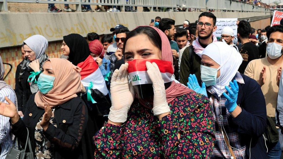 Protesters wearing face masks take part in a demonstration on International Women’s Day in Baghdad (8 March 2020)