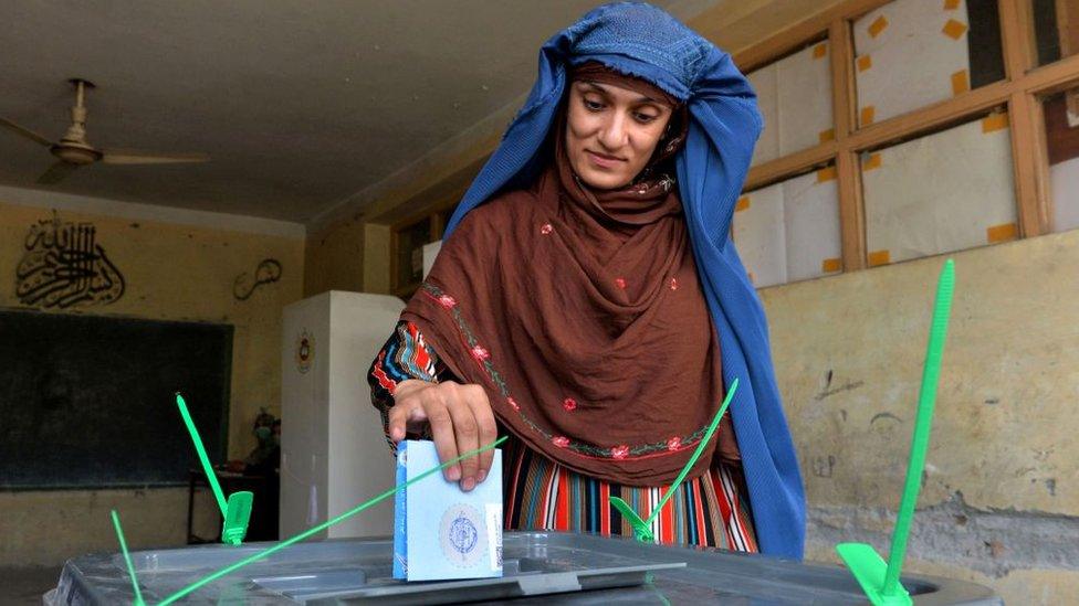 A woman casts her vote at a polling station in Jalalabad