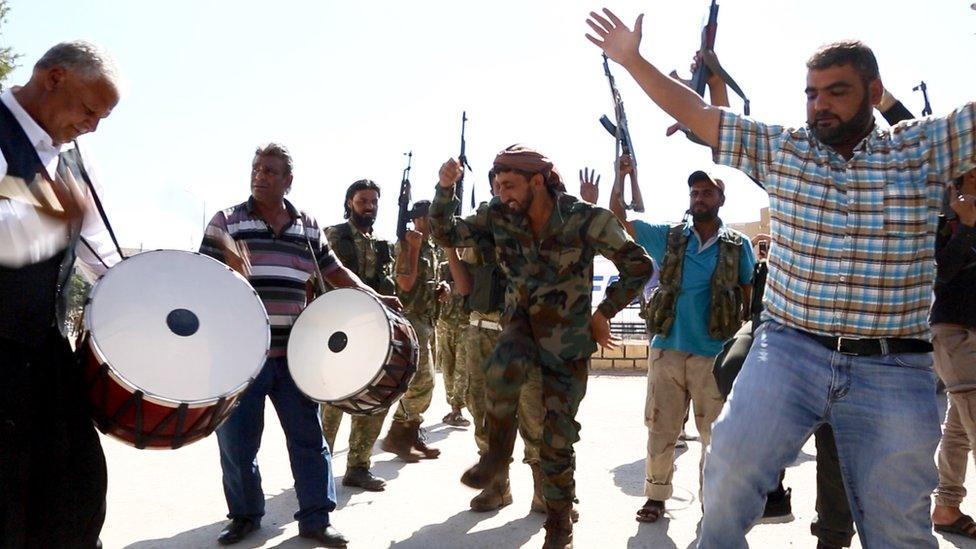 Men drumming and dancing