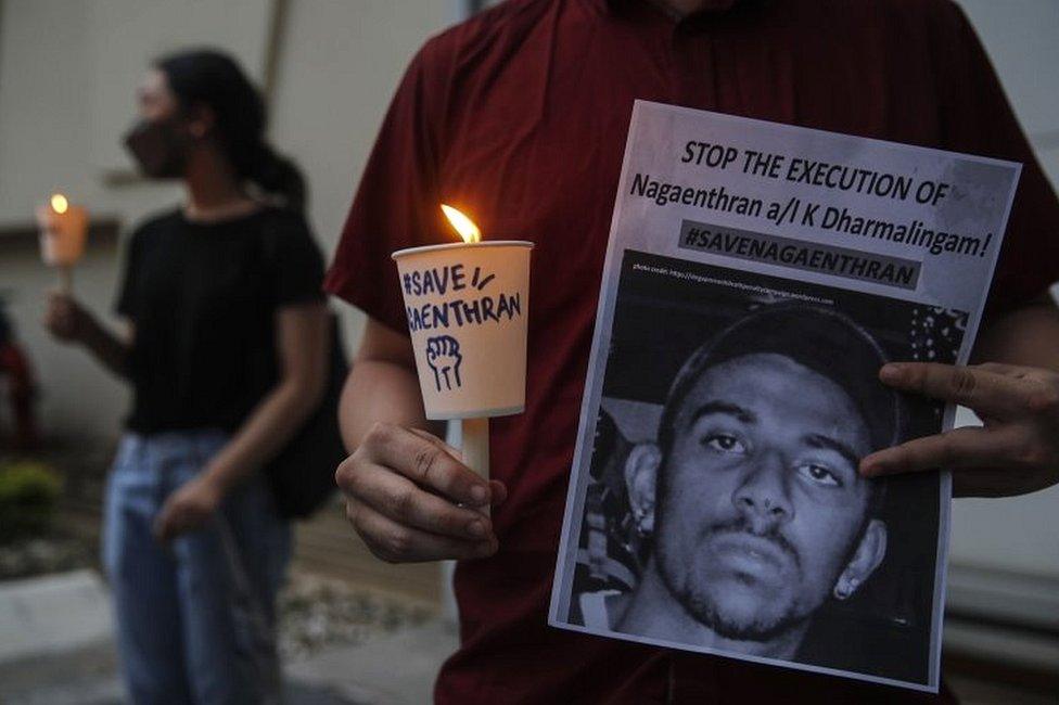 An activist holds a placard outside the Singaporean embassy in Kuala Lumpur, Malaysia, on 8 November 2021