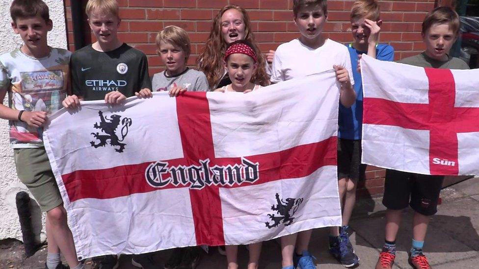 Young England fans hold flags up