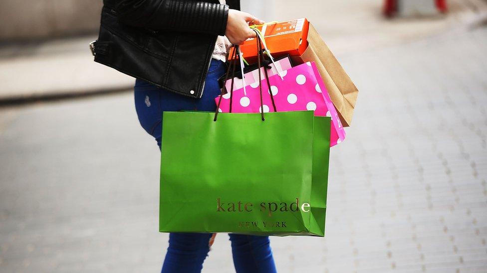 A woman walks out of a Kate Spade store in the SoHo neighborhood of Manhattan.