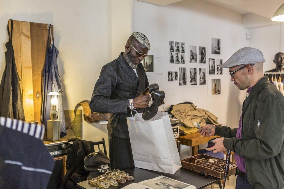 A customer makes a purchase at the till in Marche Noir.