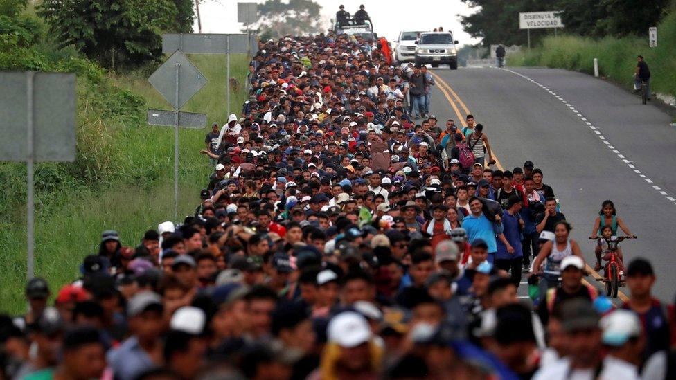 Migrants, part of a caravan travelling from Central America en route to the US, walk by the road that links Ciudad Hidalgo with Tapachula, 2 November 2018