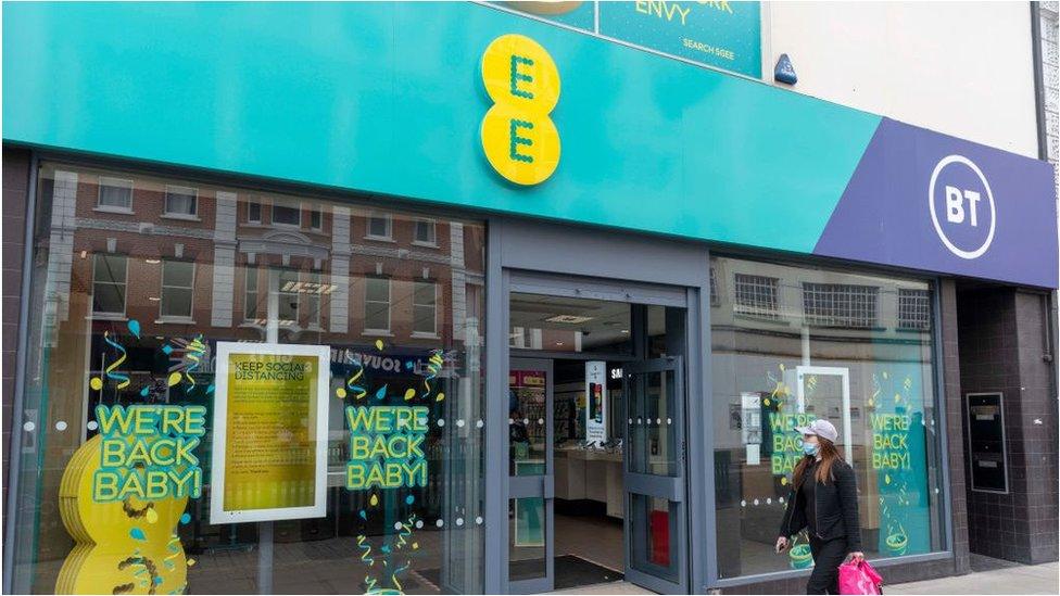 Woman walks past EE shop on Oxford Street