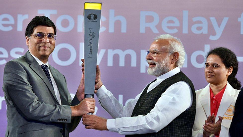 Prime Minister Narendra Modi hands over the torch to Indian chess grandmaster Viswanathan Anand during the launch of torch relay for the 44th Chess Olympiad at Indira Gandhi Stadium, on 19 June, in New Delhi