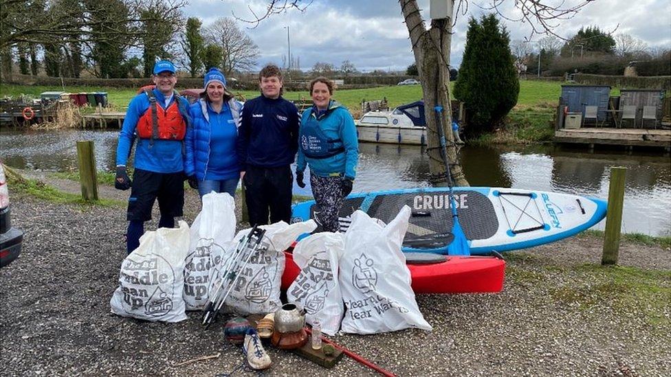 The staff with rubbish bags, kayak and paddleboard