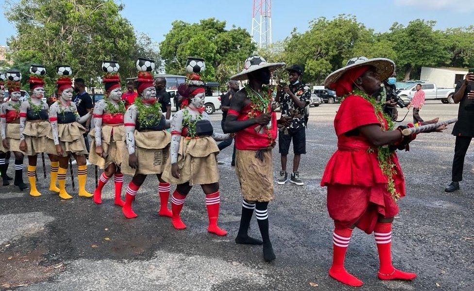 Mourners in costume with football socks and football hats