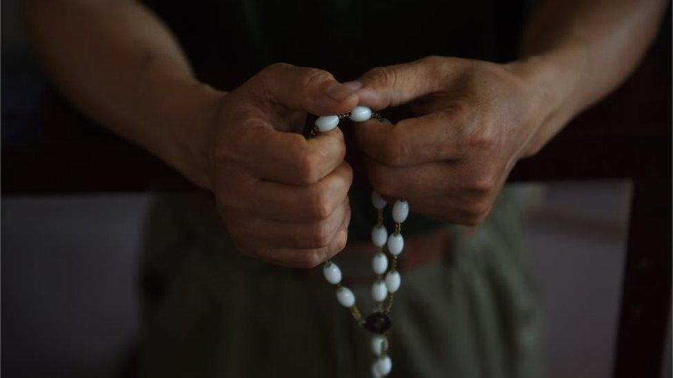 This photo taken on May 24, 2015 shows a worshipper holds rosary beads after a service celebrating the Feast of the Ascension at the "underground" Zhongxin Bridge Catholic Church in Tianjin