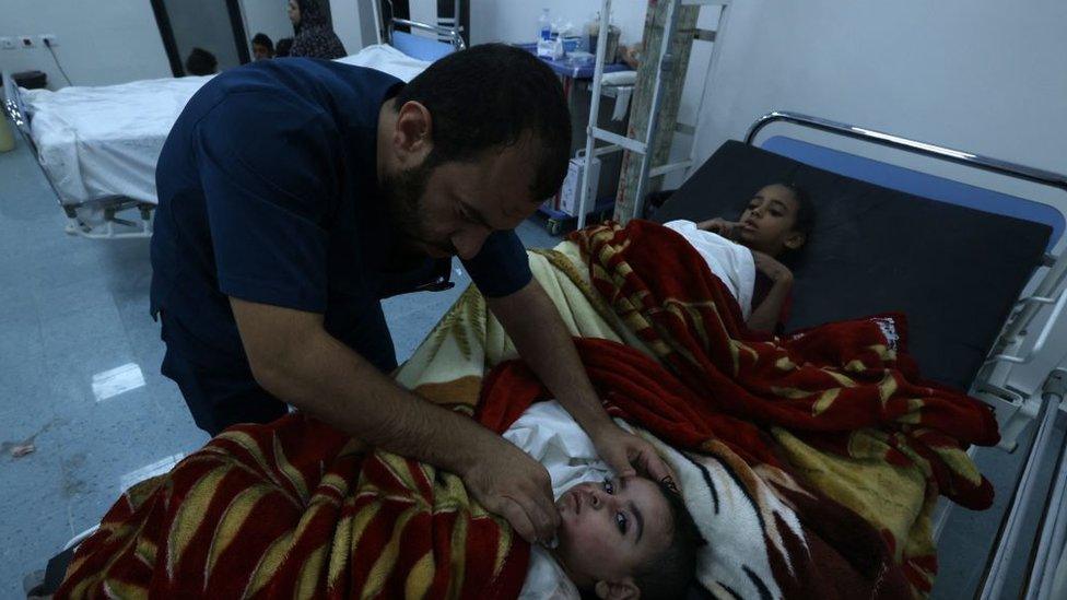 A doctor treats children in the Rafah refugee camp in southern Gaza