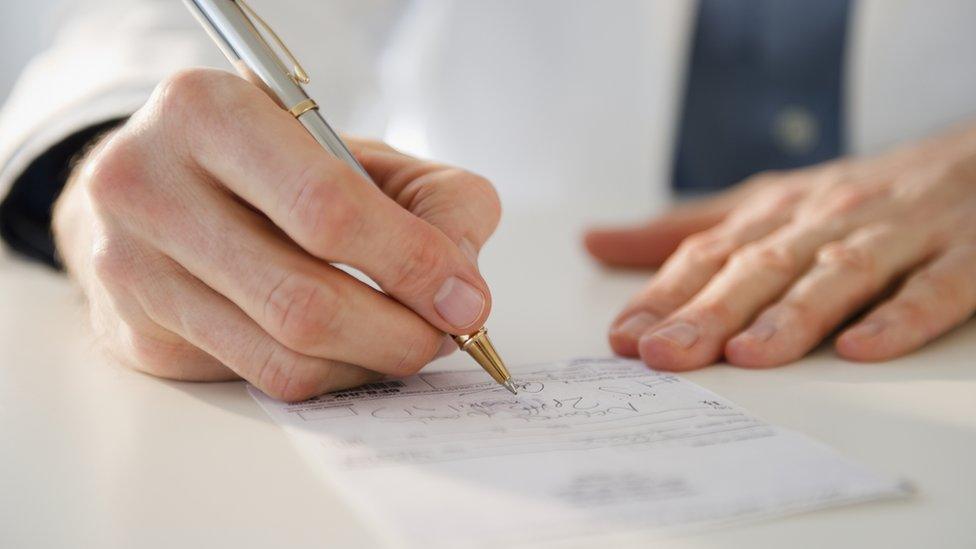 A doctor signing a letter