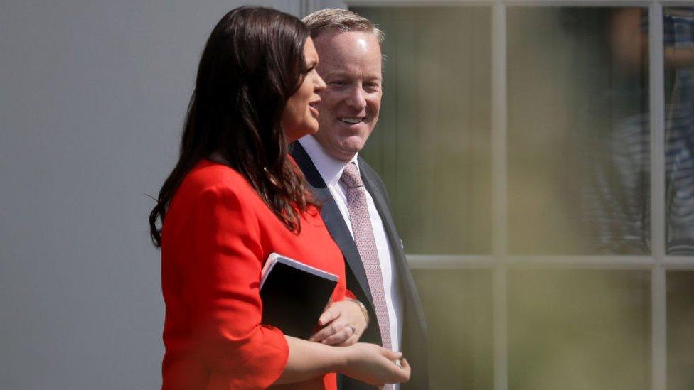 Sarah Sanders and Sean Spicer walk together in 2017