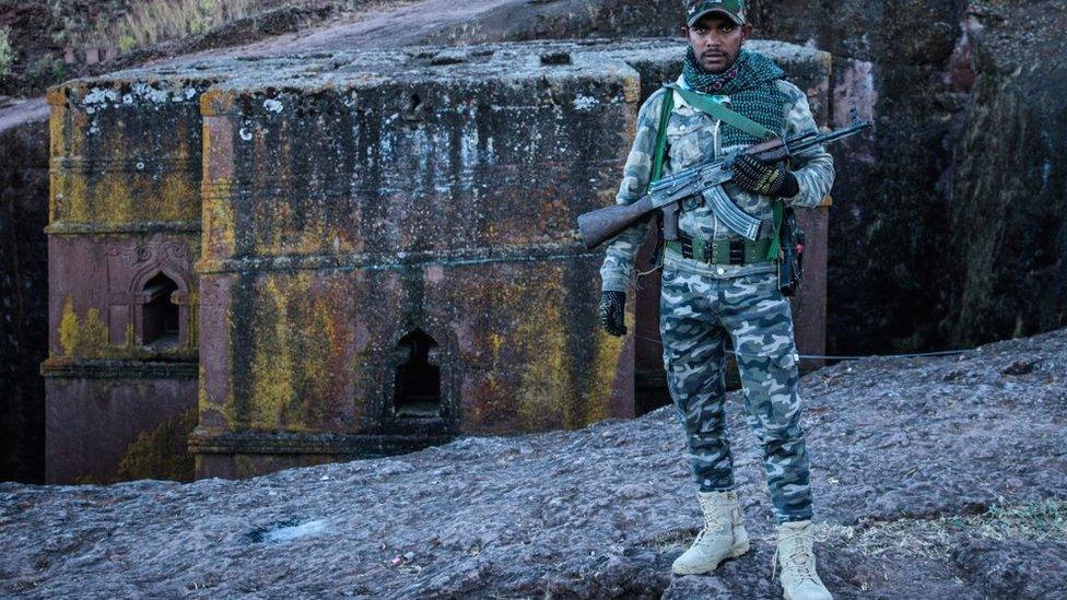 An Amhara Fano militia fighter poses at Saint George Church in Lalibela, on December 7, 2021.