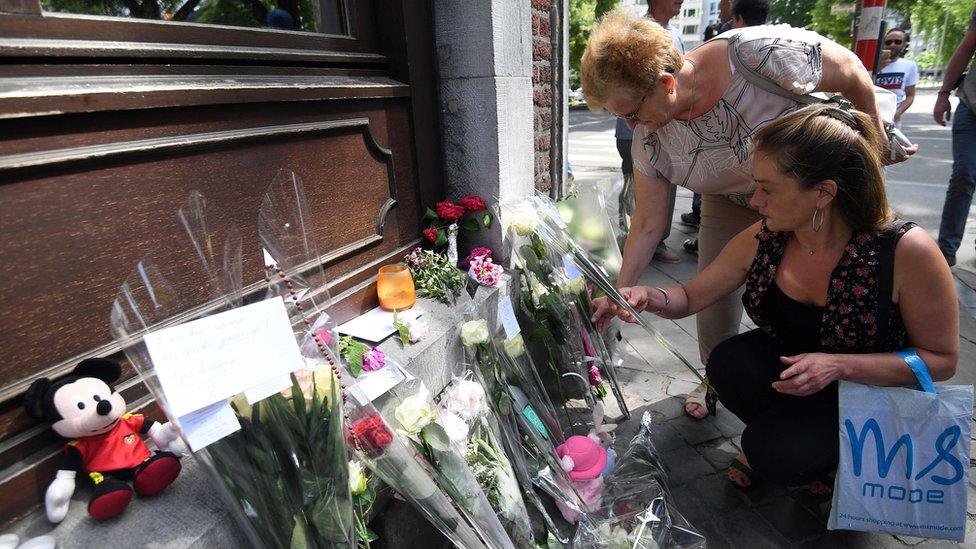 People pay tribute to the victims of the Liege's shooting on May 30, 2018, in Liege at a makeshift altar situated where the two policewomen were killed during the attack the day before.