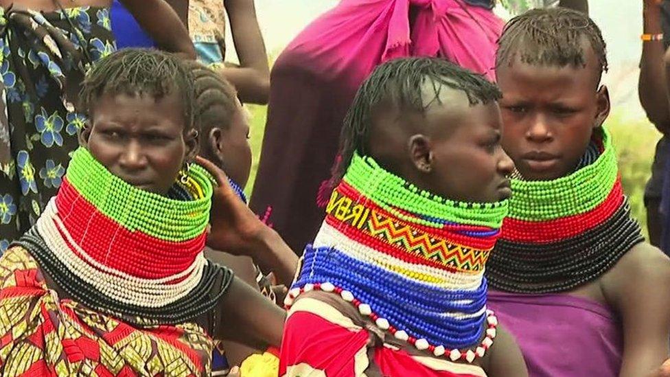 Three people waiting for food aid