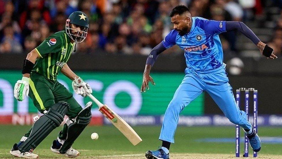 India's Hardik Pandya (R) fields the ball during the ICC men's Twenty20 World Cup 2022 cricket match between India and Pakistan at Melbourne Cricket Ground (MCG) in Melbourne on October 23, 2022