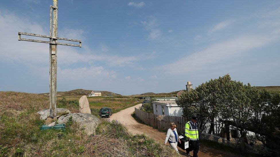 Garda Pat McIlroy and Nancy Sharkey, presiding officer for Gola Island, an island off the coast off Donegal, arrive on the island with the ballot box for the Ireland abortion referendum