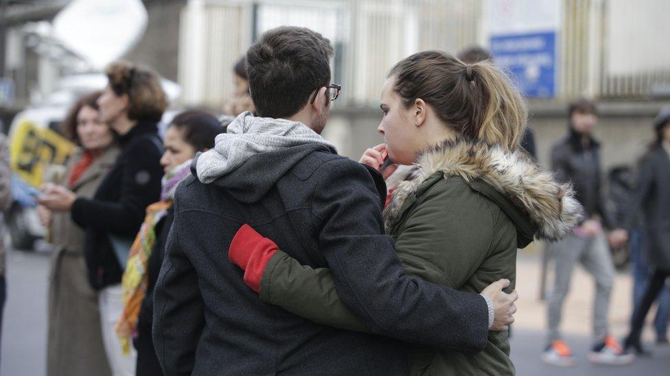 Mourners gather outside of the Carillon bar in the 10th district of Paris on November 14, 2015, following a series of attacks in and around the city, leaving at least 120 people killed.