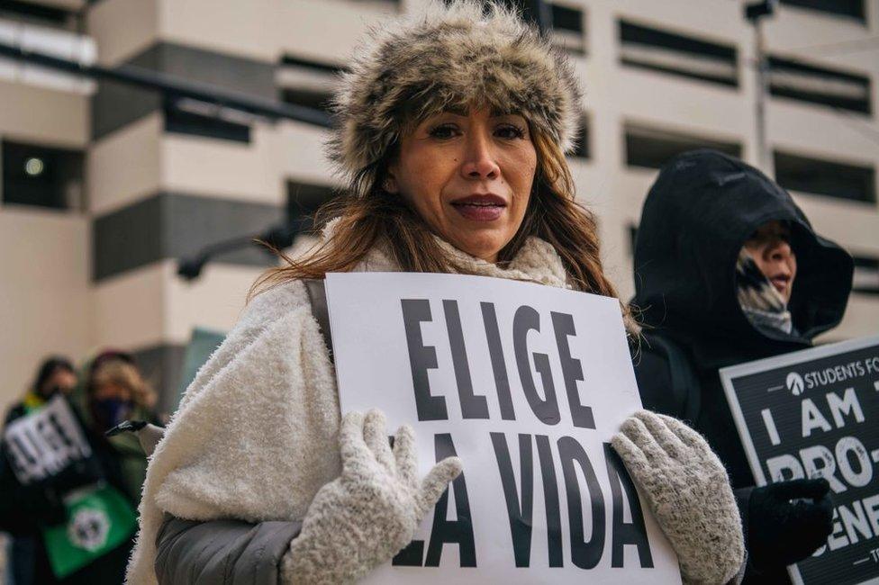 A pro-life activist holds a sign saying "choose life" at an abortion protest in Dallas, Texas in January 2022