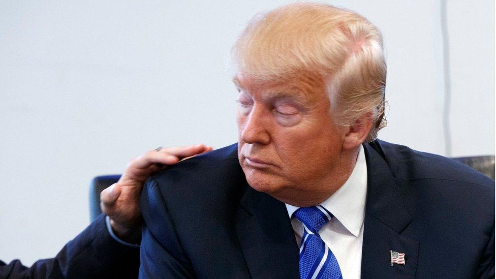 Man puts his hand on the shoulder of Donald Trump during a meeting at Trump Tower (7 Oct. 2016)