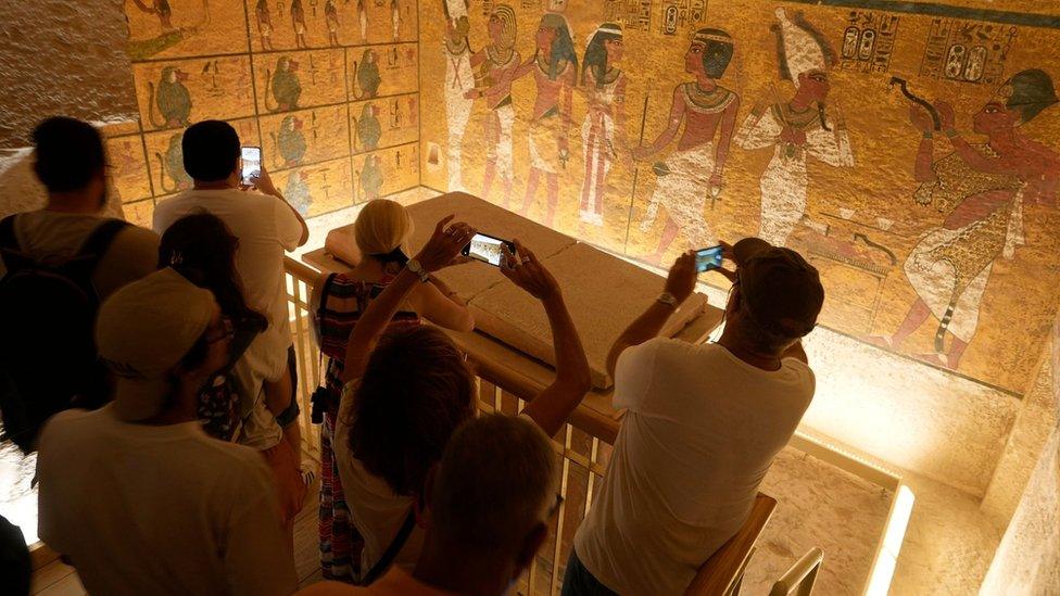 Tourists look at the walls of Tutankhamun's burial chamber, in the Valley of the Kings in Luxor, Egypt (4 November 2022)