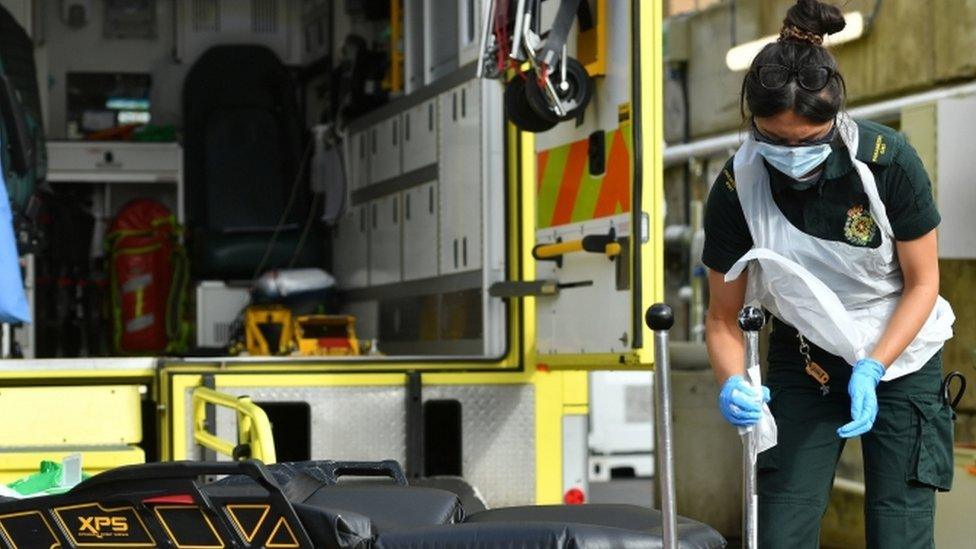 A paramedic cleans down equipment in the ambulance decontamination area outside the Respiratory Assessment Unit