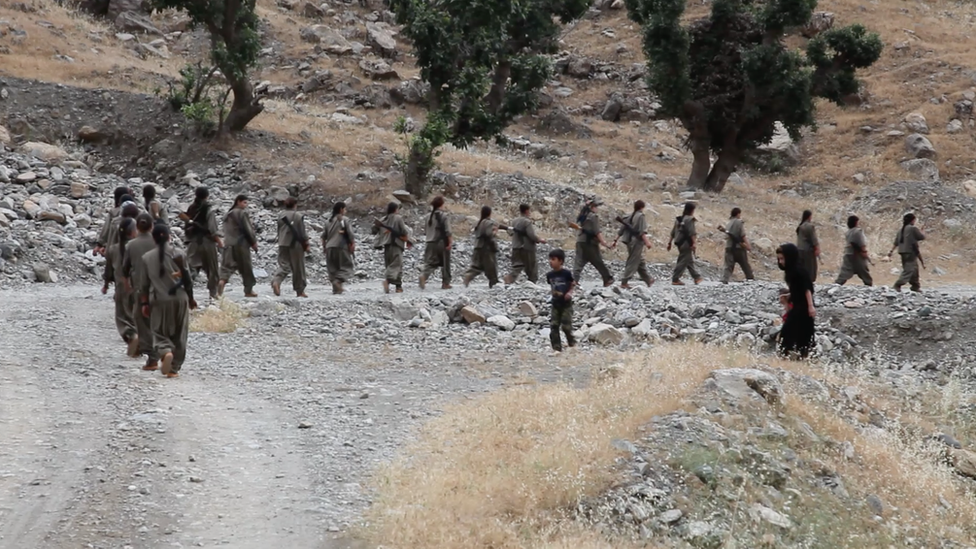 PKK fighter march from their base in Iraq towards the frontline with Islamic State in Syria