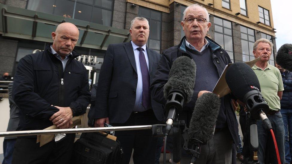 Mickey McKinney speaks to the media outside Derry's City Hotel in Londonderry, with his brothers, John and Joe