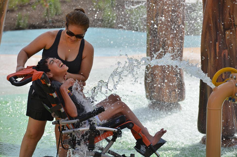 A boy and his mother enjoy a splash zone