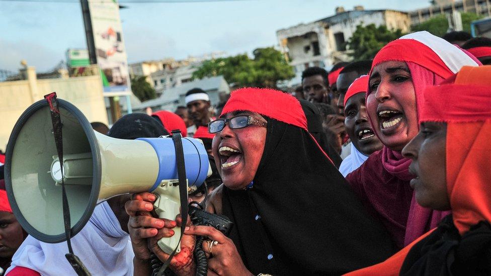 women with megaphone and red headbands