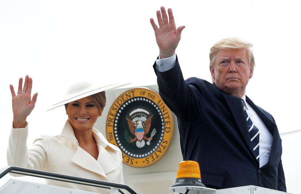 Mr and Mrs Trump waving outside the door to Air Force One