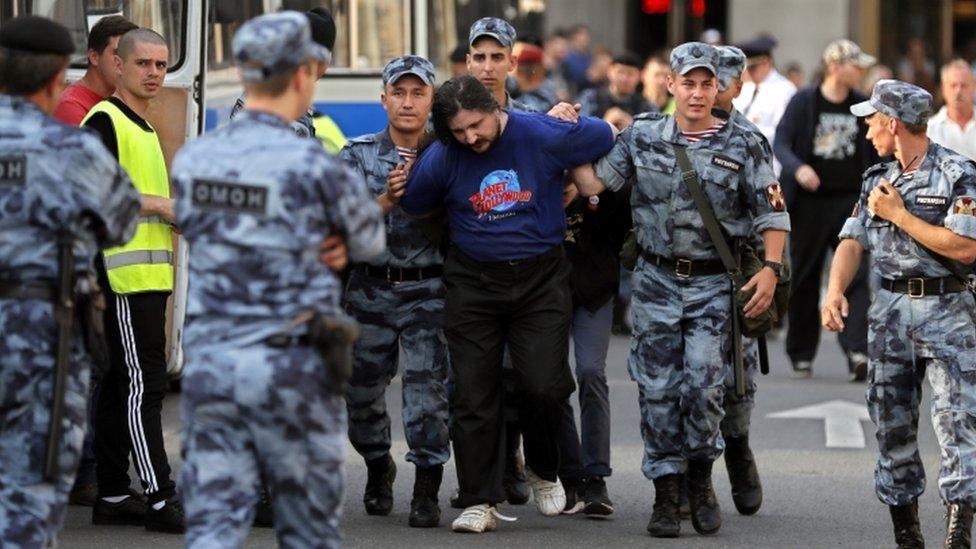 A protester is arrested by uniformed police officers on 9 September 2018.