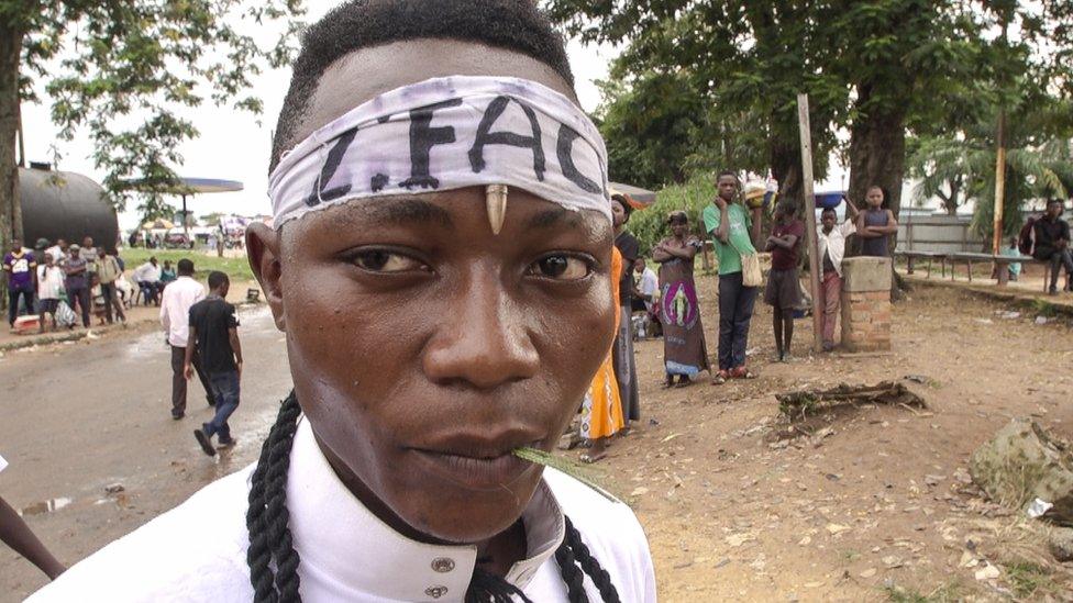 Kamuina member - Militia member standing in Kananga town.