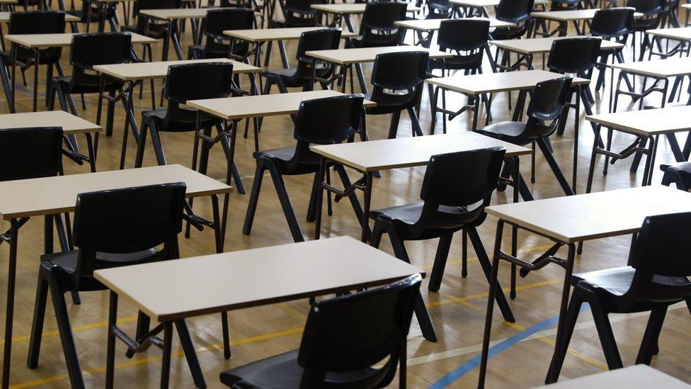 exam hall with lots of desks and empty chairs