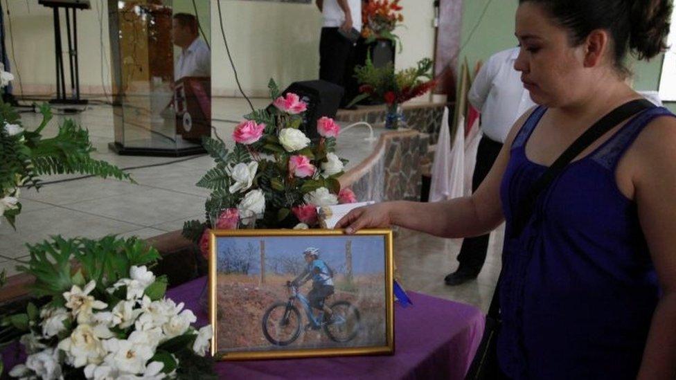 A woman shows a picture of Lesbia Yaneth Urquia at her funeral. 8 July 2016