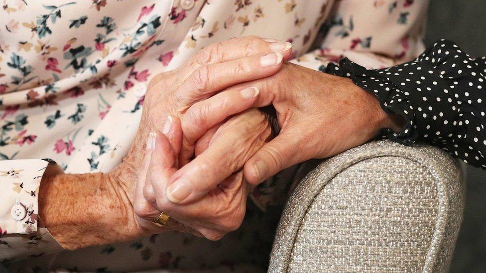 Elderly people holding hands