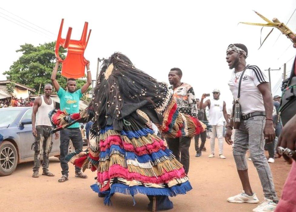 A man in a masquerade costume performing in the streets of Arondizuogu during the Ikeji Festival in Nigeria