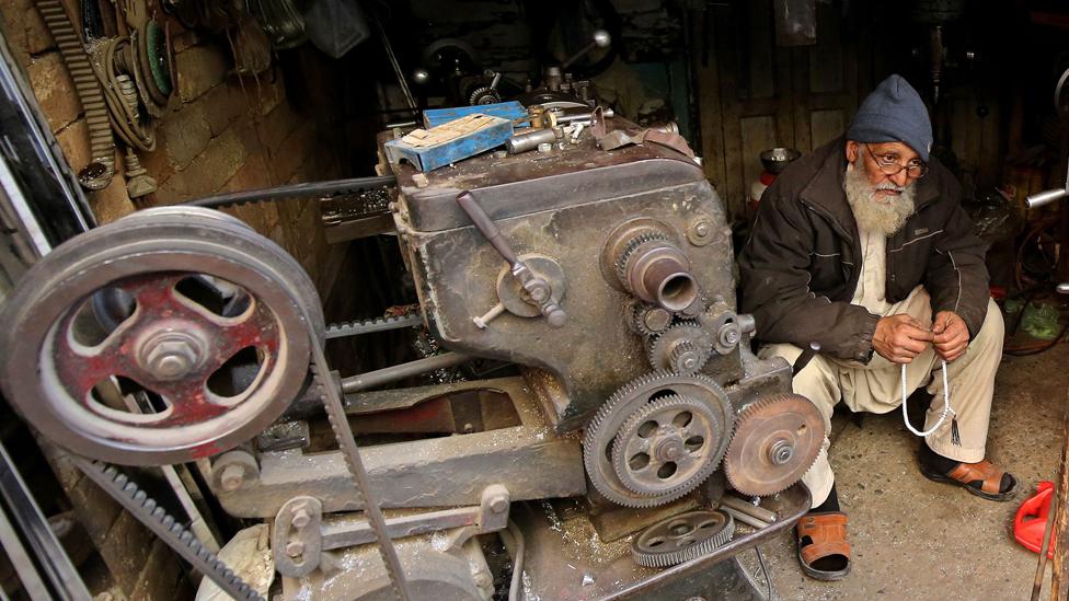 A worker waits for the electricity restoration after the country plunged into darkness following a major power breakdown, in Peshawar, Pakistan, on 23 January 2023