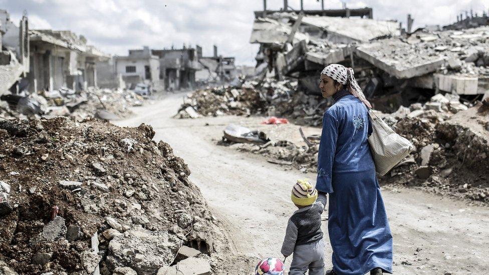 Bombed-street-with-a-mother-and-son.