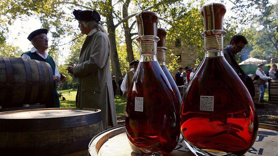 Actors dressed in period costumes gather behind freshly produced whiskey prior to the dedication ceremony for the George Washington Distillery in Mount Vernon, Virginia.