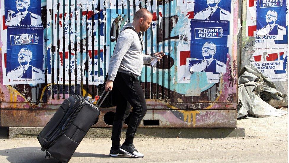 A man walks past an election poster of Serbian Radical Party leader Vojislav Seselj in Belgrade, Serbia (23 April 2016)