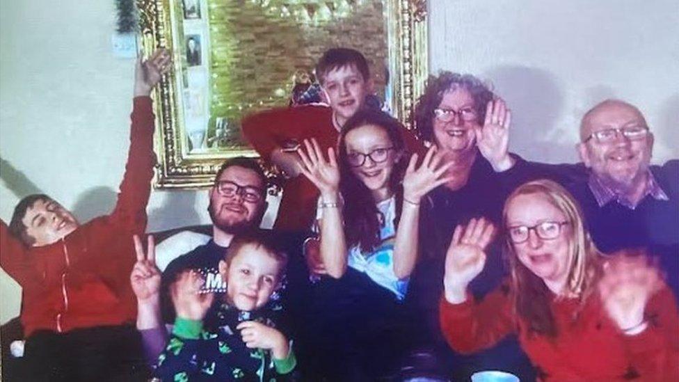 A man, two women, one girl and four boys pictured at a family gathering on New Year's Eve.