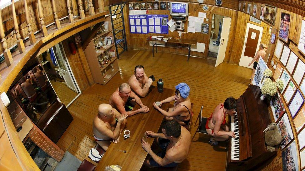 Members of the Cryophile winter swimmers club gather inside the wooden clubhouse