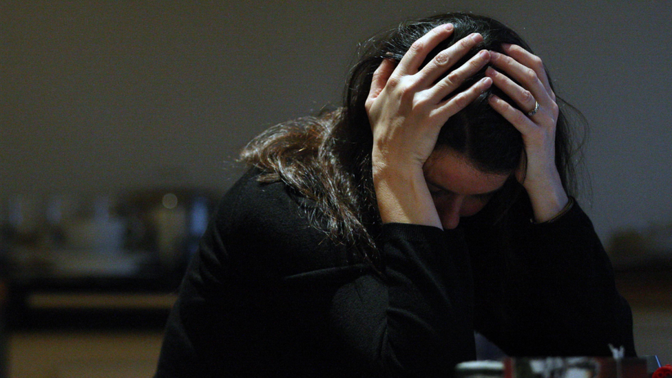 Woman sat with her head in her hands