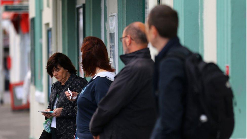 People wait to board a rail replacement bus outside Seaford Station in East Sussex