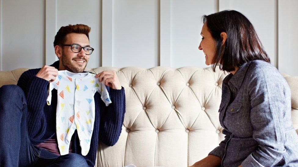 Couple looking at baby clothes