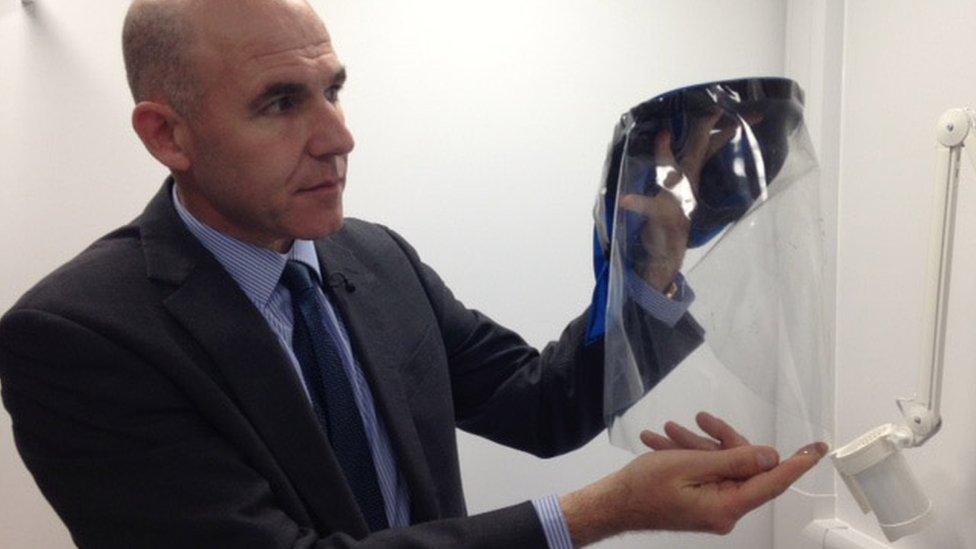 Doctor holding up visor some skin patients have to wear