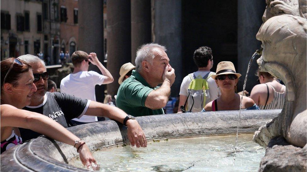 Tourists refresh at a fountain in front of the Pantheon monument during an unusually early summer heatwave in Rome, 24 June 2019